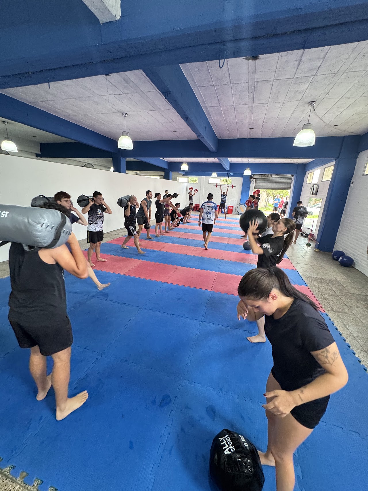 Clase de entrenamiento funcional con bolsas y pesas rusas en MONFIT